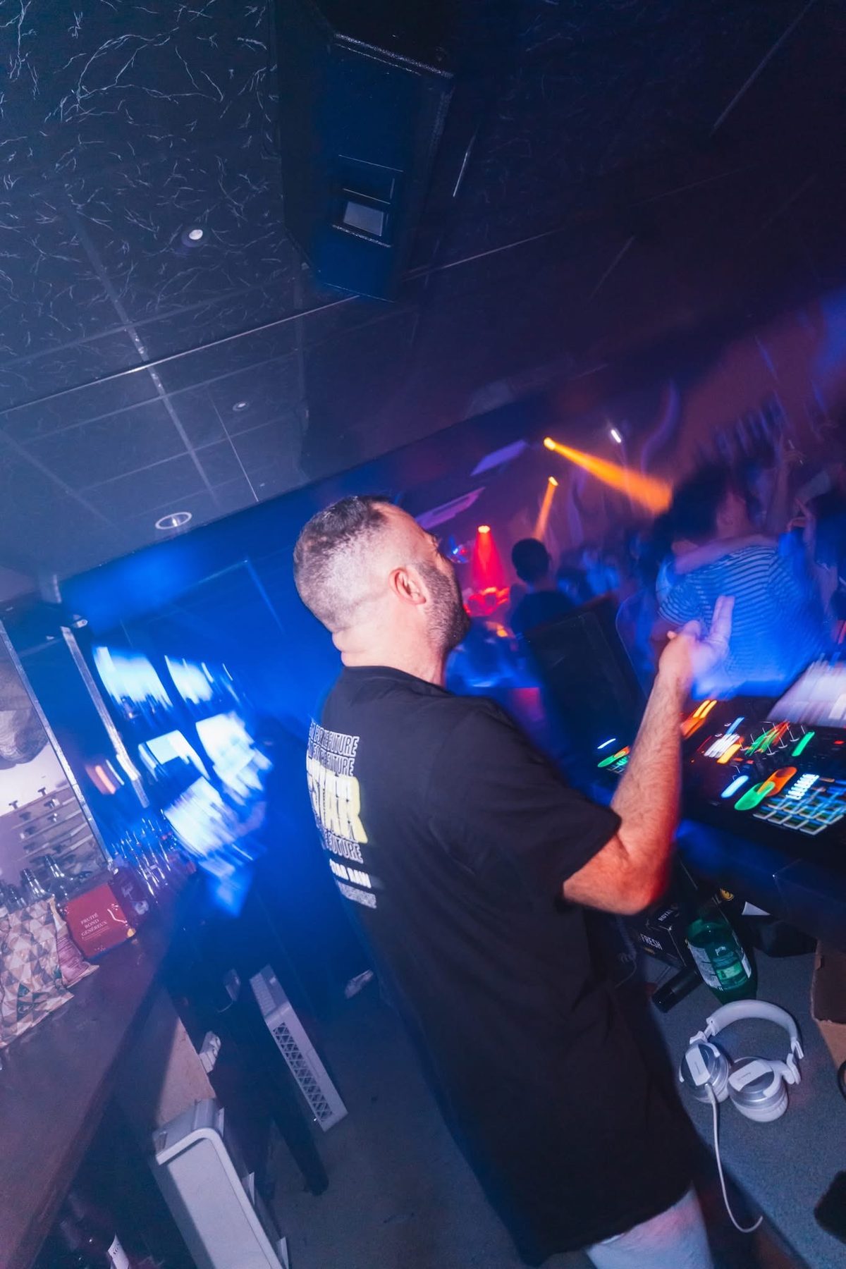 JeremieV mixant sous les lumières bleues d'un club