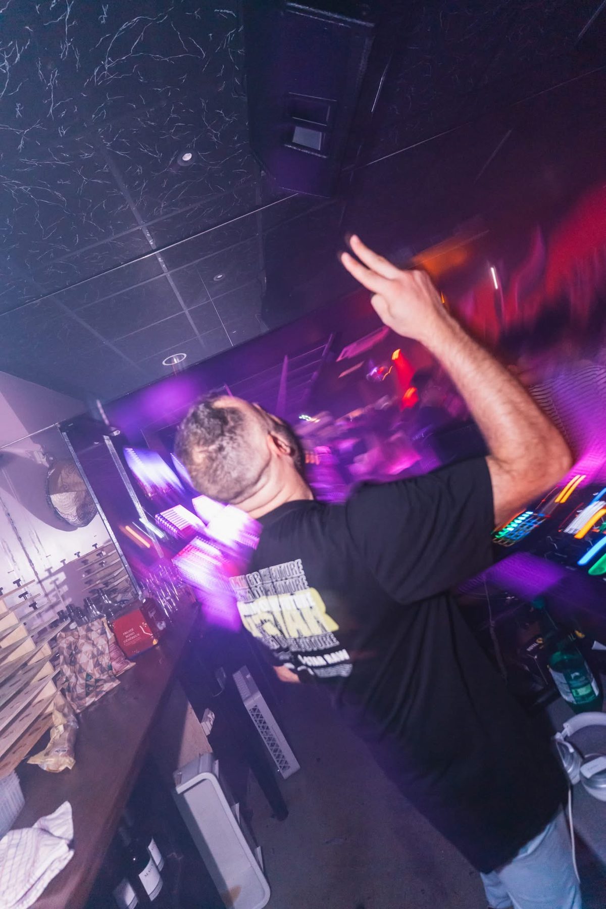 JeremieV en discothèque, mains en l'air sur la piste